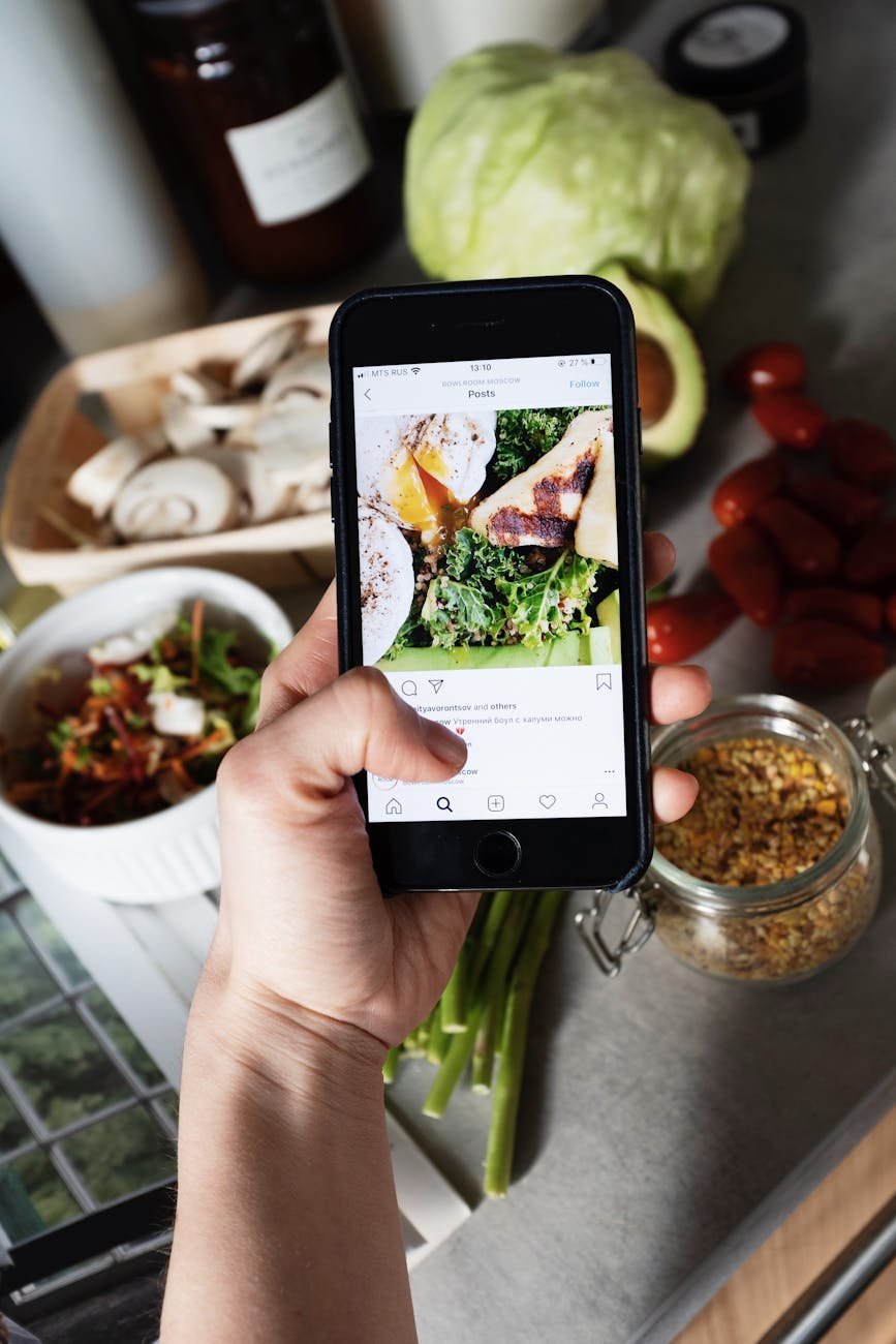 crop faceless blogger showing food photo on smartphone screen