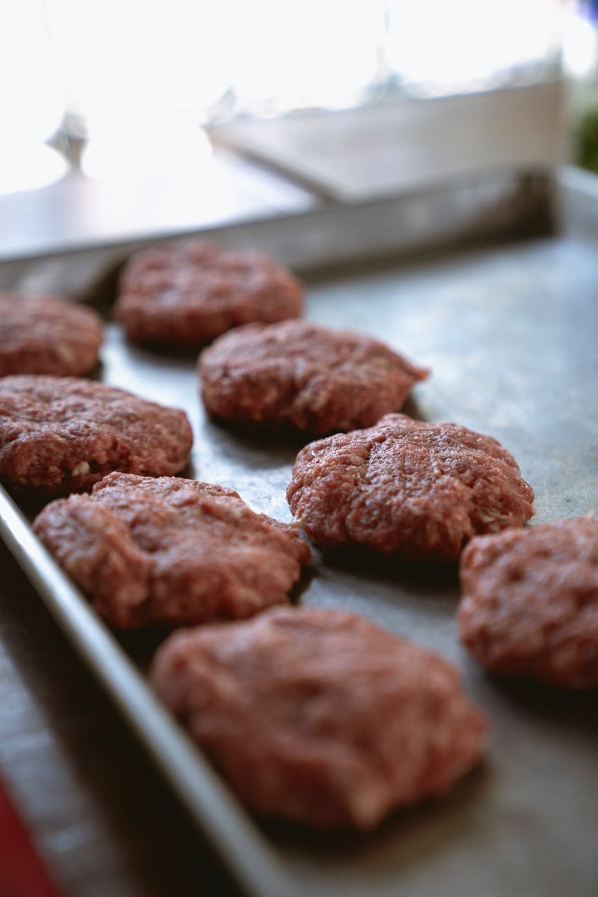 burger patties on steel tray